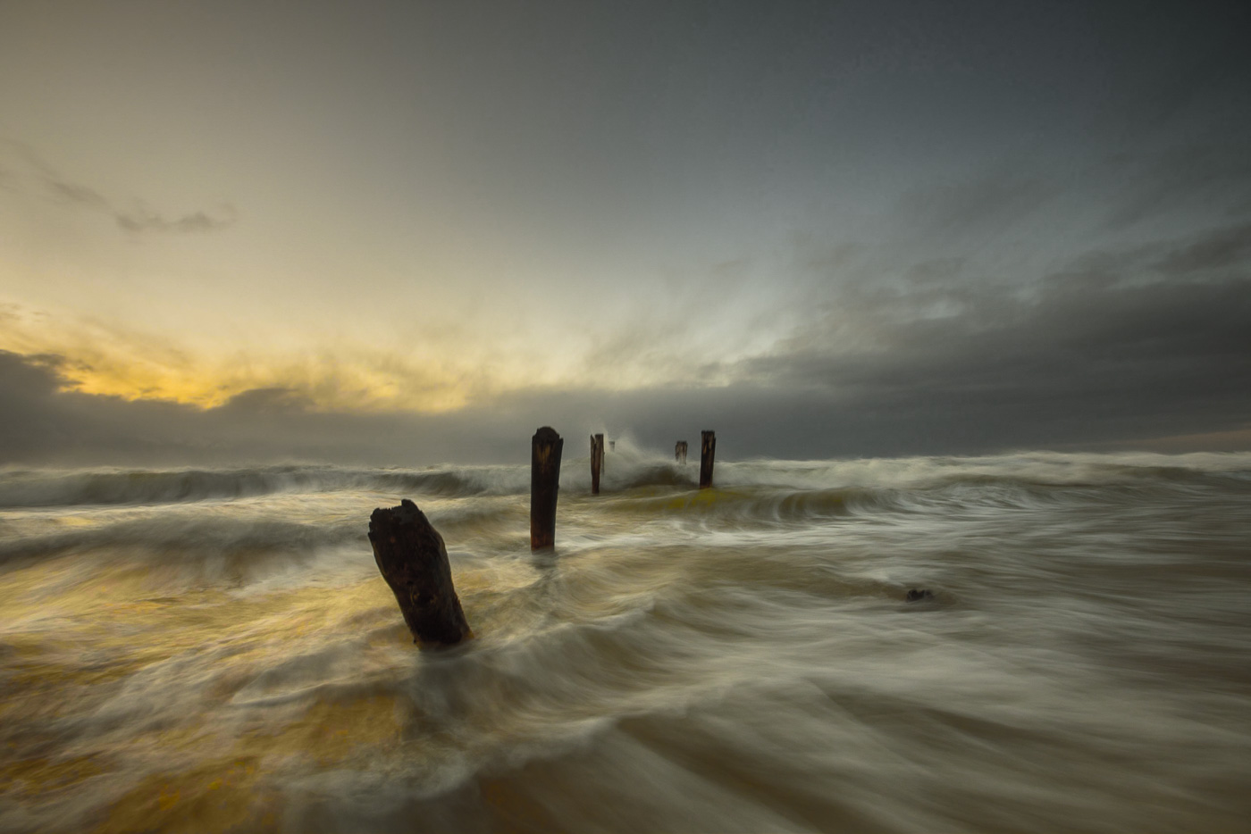 Old Pier at St Clair Beach in a cloudy, golden sunrise