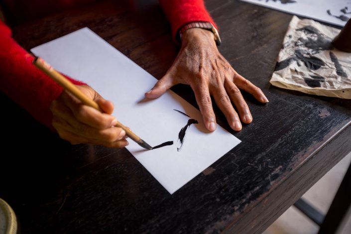 Hands of traditional calligrapher in Hoi An, Vietnam
