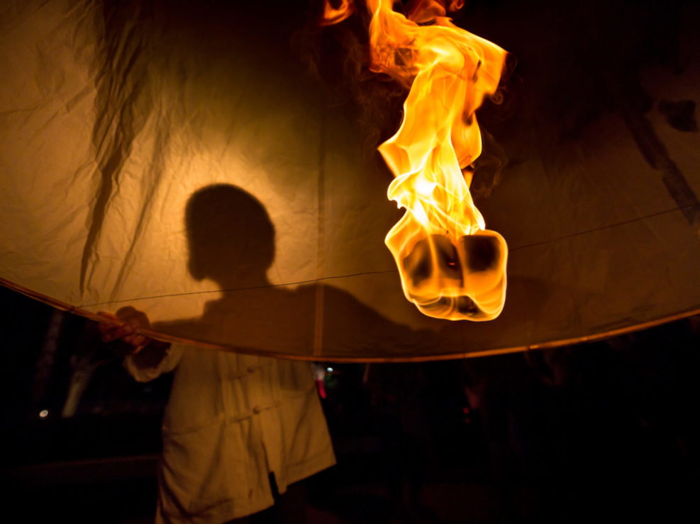 Silhouette of person holding sky lantern